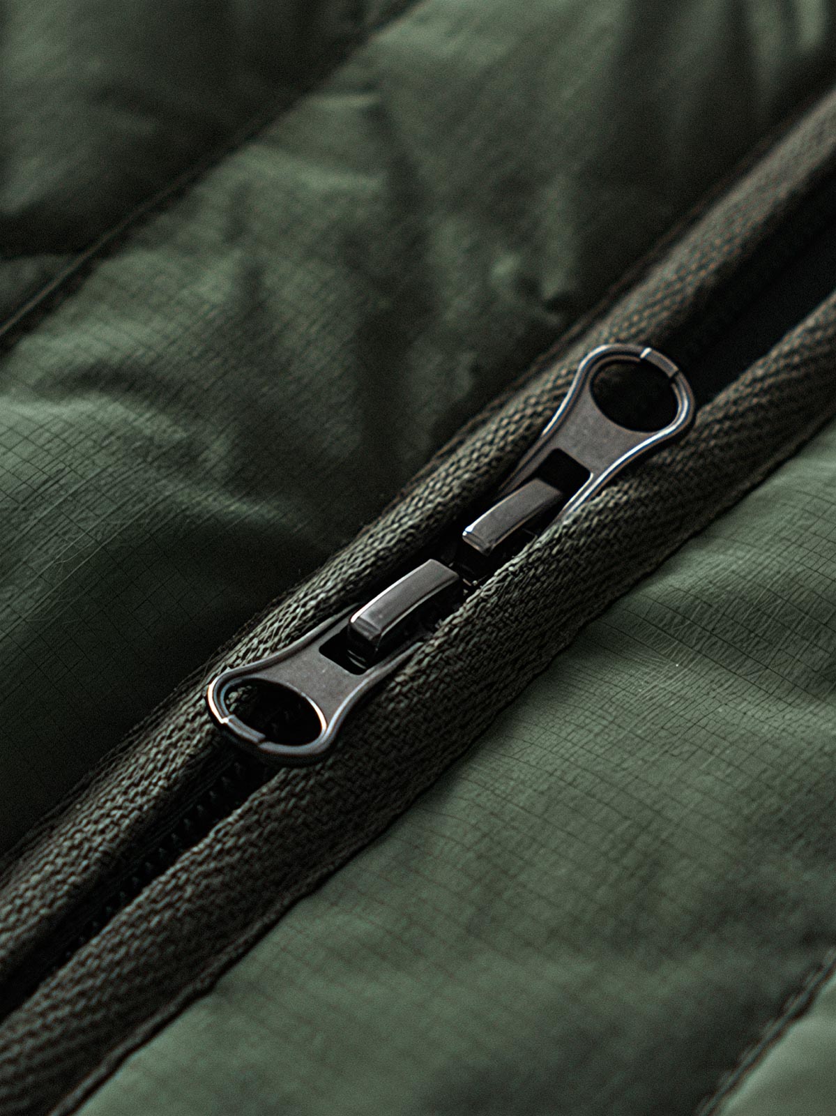 製品画像
「テフロン加工 三防テクノロジー ダイヤキルティング中綿ジャケット全体像。防水、防油、防汚の三防機能と3M™シンサレート中綿が特徴で、軽量で暖かい冬のアウター」

詳細画像
「テフロン加工 ダイヤキルティング中綿ジャケットのダブルジッパーとスナップボタンのディテールクローズアップ。防風性とデザイン性を両立」