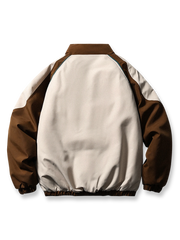 製品画像
「目を引くバイカラーとアーチ型切り替えデザインを特徴としたスタンドカラー中綿ジャケット。防風性と保温性に優れ、冬のアウトドアや日常使いに最適なスポーティなルーズフィットジャケットの全体図」

詳細画像
「バイカラーのアーチパターン切り替えデザインとジッパー付きスタンドカラーが特徴の中綿ジャケット。防風性と耐久性を兼ね備えたディテールのクローズアップ」
