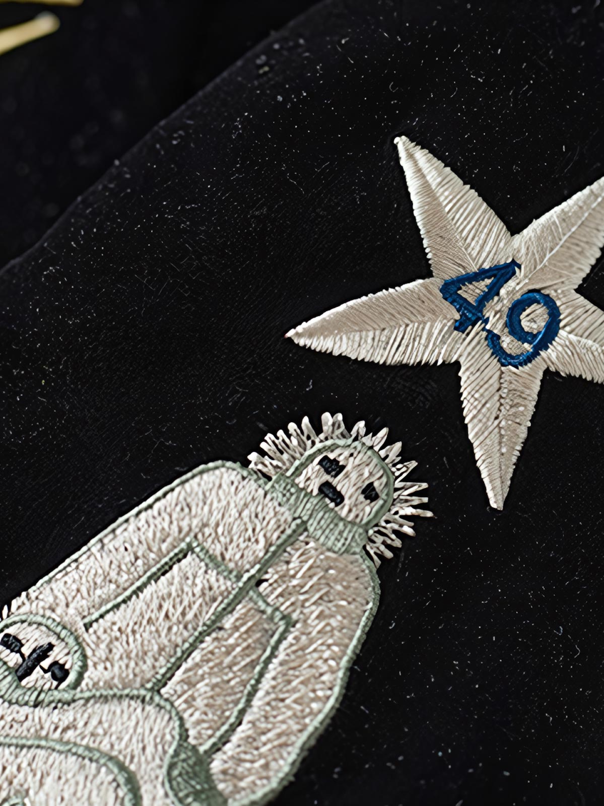 製品画像
1950年代アラスカをテーマにしたヴィンテージ刺繍リバーシブルスカジャン。片面はブラックベルベット素材にホッキョクグマ刺繍、もう片面はサテンポリエステルにアラスカ地図とトナカイ刺繍。どちらの面も印象的なデザインが施されています。

詳細画像
YKK製スライダージッパー、ライトニングデザインとホッキョクグマの刺繍ディテール。丁寧な仕上げが際立つ。