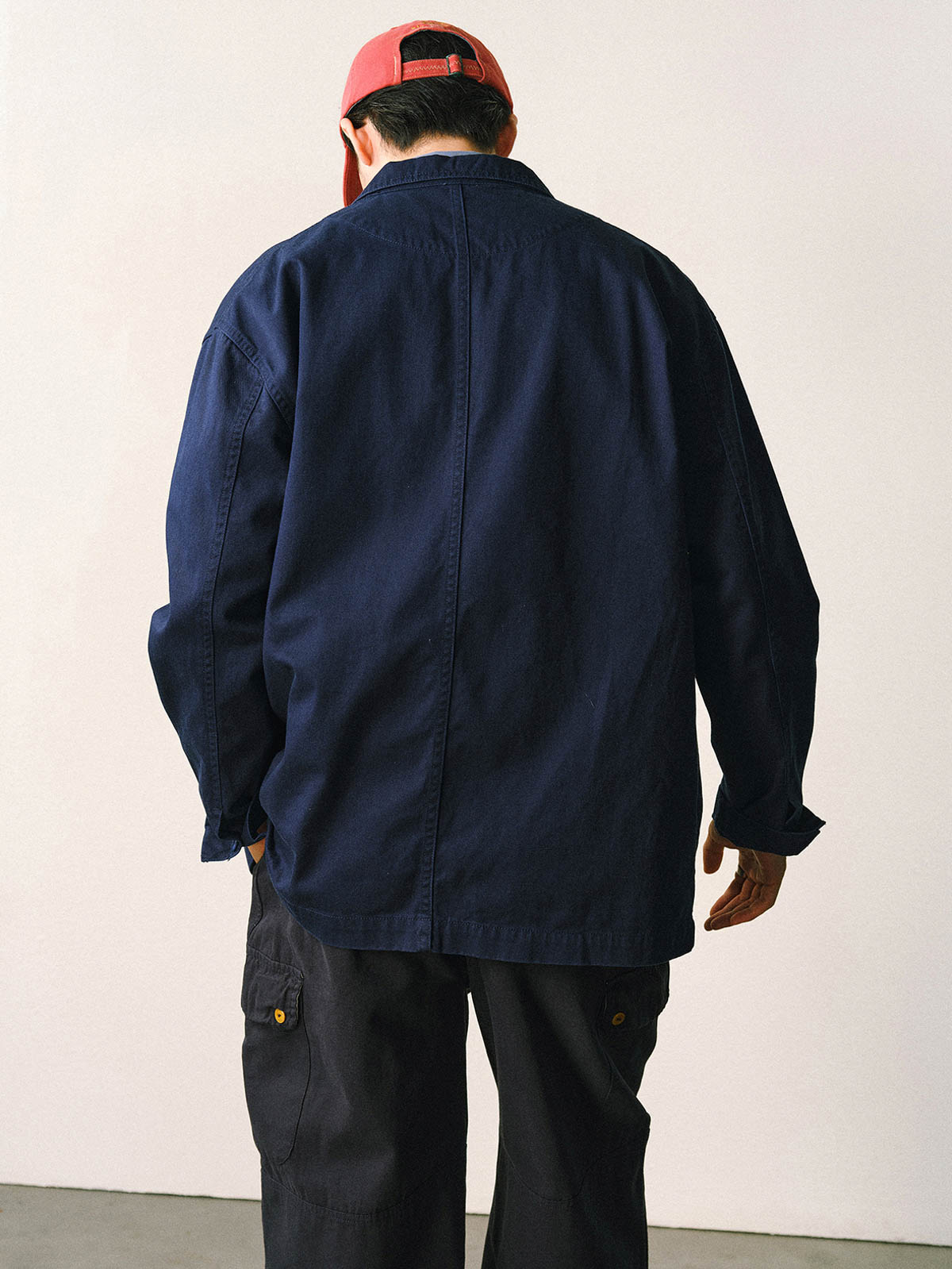 詳細画像
「バイカラーの胸ポケットやアシンメトリーな複合ポケットのディテールクローズアップ。酵素ウォッシュ加工による自然な色褪せ感と軽い起毛感が特徴。」

モデル画像
「モデルがアーミーグリーンのウォッシュ加工ワークテイストテーラードジャケットをデニムと合わせたヴィンテージ風カジュアルワークコーディネート。」