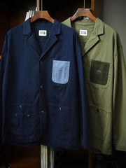 製品画像
「ウォッシュ加工を施したワークテイストテーラードジャケット全体イメージ。スーツのフォーマル感とワークウェアの実用性を融合し、ヴィンテージ感を演出したデザイン。」

詳細画像
「バイカラーの胸ポケットやアシンメトリーな複合ポケットのディテールクローズアップ。酵素ウォッシュ加工による自然な色褪せ感と軽い起毛感が特徴。」