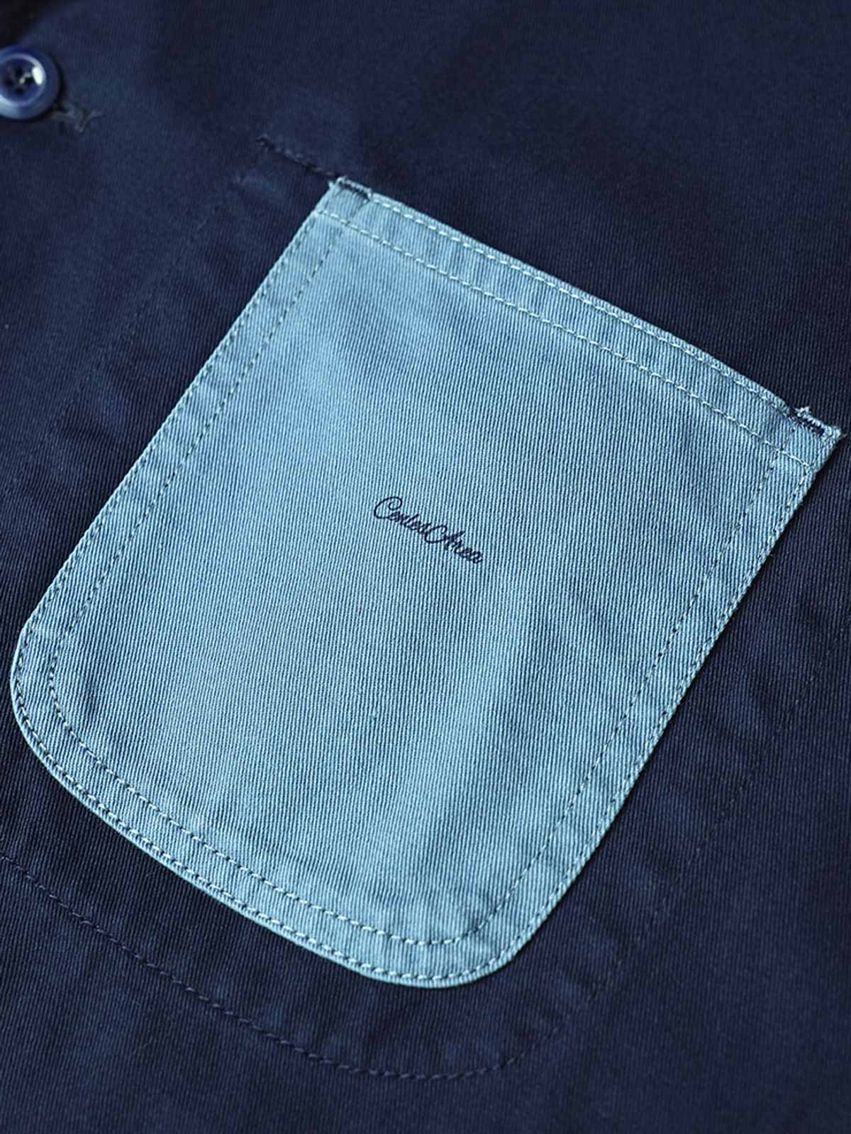 製品画像
「ウォッシュ加工を施したワークテイストテーラードジャケット全体イメージ。スーツのフォーマル感とワークウェアの実用性を融合し、ヴィンテージ感を演出したデザイン。」

詳細画像
「バイカラーの胸ポケットやアシンメトリーな複合ポケットのディテールクローズアップ。酵素ウォッシュ加工による自然な色褪せ感と軽い起毛感が特徴。」