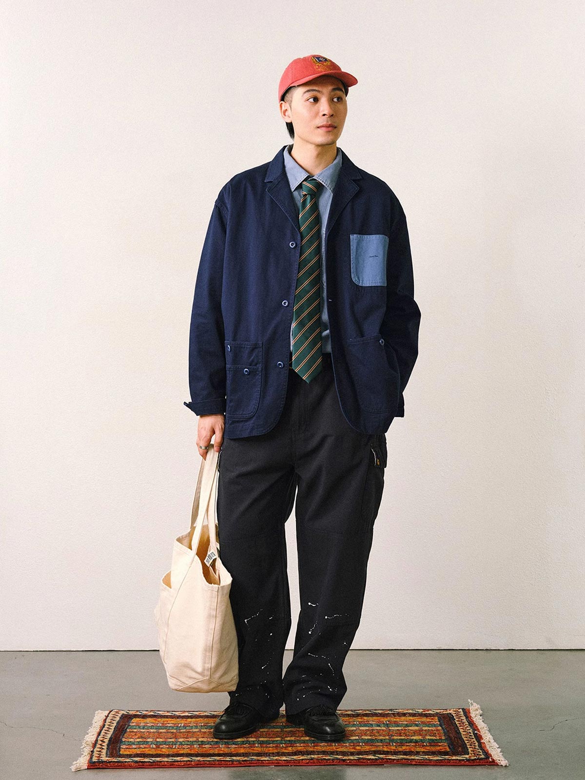 詳細画像
「バイカラーの胸ポケットやアシンメトリーな複合ポケットのディテールクローズアップ。酵素ウォッシュ加工による自然な色褪せ感と軽い起毛感が特徴。」

モデル画像
「モデルがアーミーグリーンのウォッシュ加工ワークテイストテーラードジャケットをデニムと合わせたヴィンテージ風カジュアルワークコーディネート。」