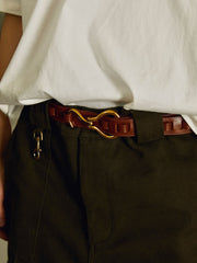 レトロフックレザーベルトの真鍮フックとトップグレイン牛革のクローズアップ。耐久性と快適さを兼ね備え、細部にわたるクラフトマンシップが光るデザインです。