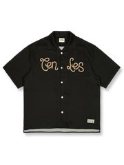 オレンジレッドの背景にレトロプリントが施されたキューバカラーの半袖シャツの正面ビュー。直線的でゆったりとしたカットが特徴で、リラックスしたカジュアルスタイルを提供します。