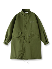 製品画像: M-65改良型 厚手パーカーコート（ロング）の正面全体画像。クラシックなM-65ミリタリーデザインを基に改良されたコートで、厚手の中綿入り構造が保温性を高め、寒冷地にも対応。シンプルながら存在感のあるデザインが特徴。

詳細画像: M-65改良型 厚手パーカーコート（ロング）のディテールクローズアップ画像。ウエストライン調整が可能なドローコードと、鍵やスマートフォンなどの収納に便利な多機能ポケットのデザインが映える。防風性を考慮した耐久性の高いコットン素材の質感が際立つ。