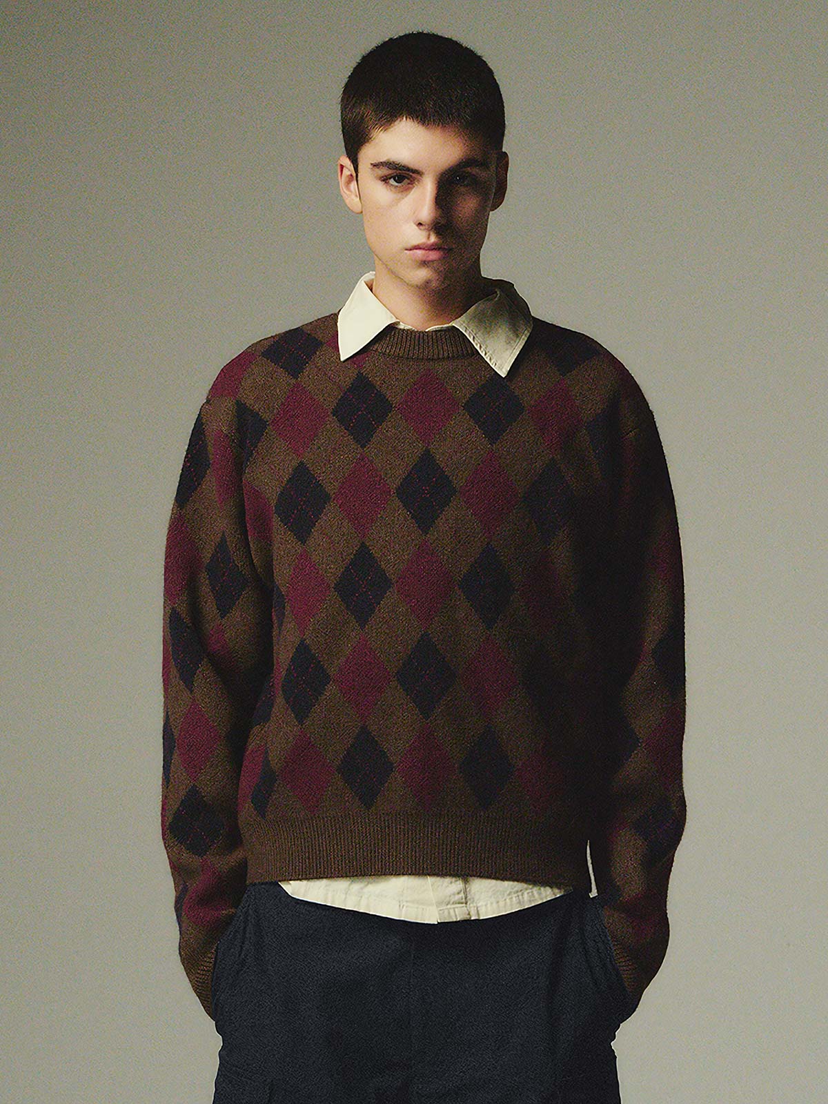 詳細画像: ダイヤ柄の滑らかな編み地のディテールクローズアップ画像。軽量で柔らかい混紡素材が持つ快適さと暖かさを示す。

モデル画像: ダイヤ柄クルーネックニットを着用したモデルによるカジュアルコーディネートイメージ。デニムやワークパンツとの組み合わせでレトロなスタイルを楽しめる。