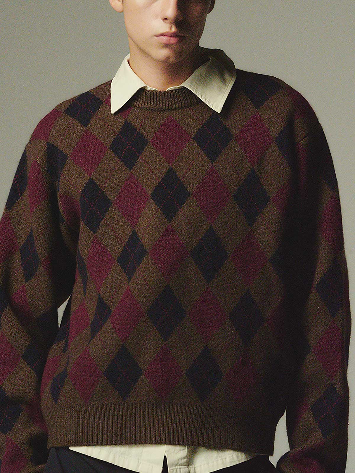 詳細画像: ダイヤ柄の滑らかな編み地のディテールクローズアップ画像。軽量で柔らかい混紡素材が持つ快適さと暖かさを示す。

モデル画像: ダイヤ柄クルーネックニットを着用したモデルによるカジュアルコーディネートイメージ。デニムやワークパンツとの組み合わせでレトロなスタイルを楽しめる。