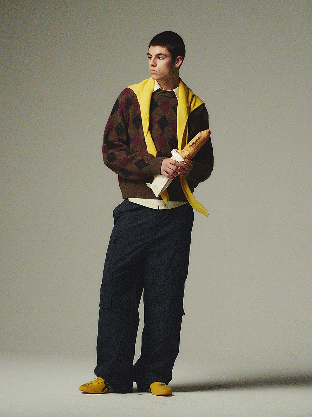 詳細画像: ダイヤ柄の滑らかな編み地のディテールクローズアップ画像。軽量で柔らかい混紡素材が持つ快適さと暖かさを示す。

モデル画像: ダイヤ柄クルーネックニットを着用したモデルによるカジュアルコーディネートイメージ。デニムやワークパンツとの組み合わせでレトロなスタイルを楽しめる。