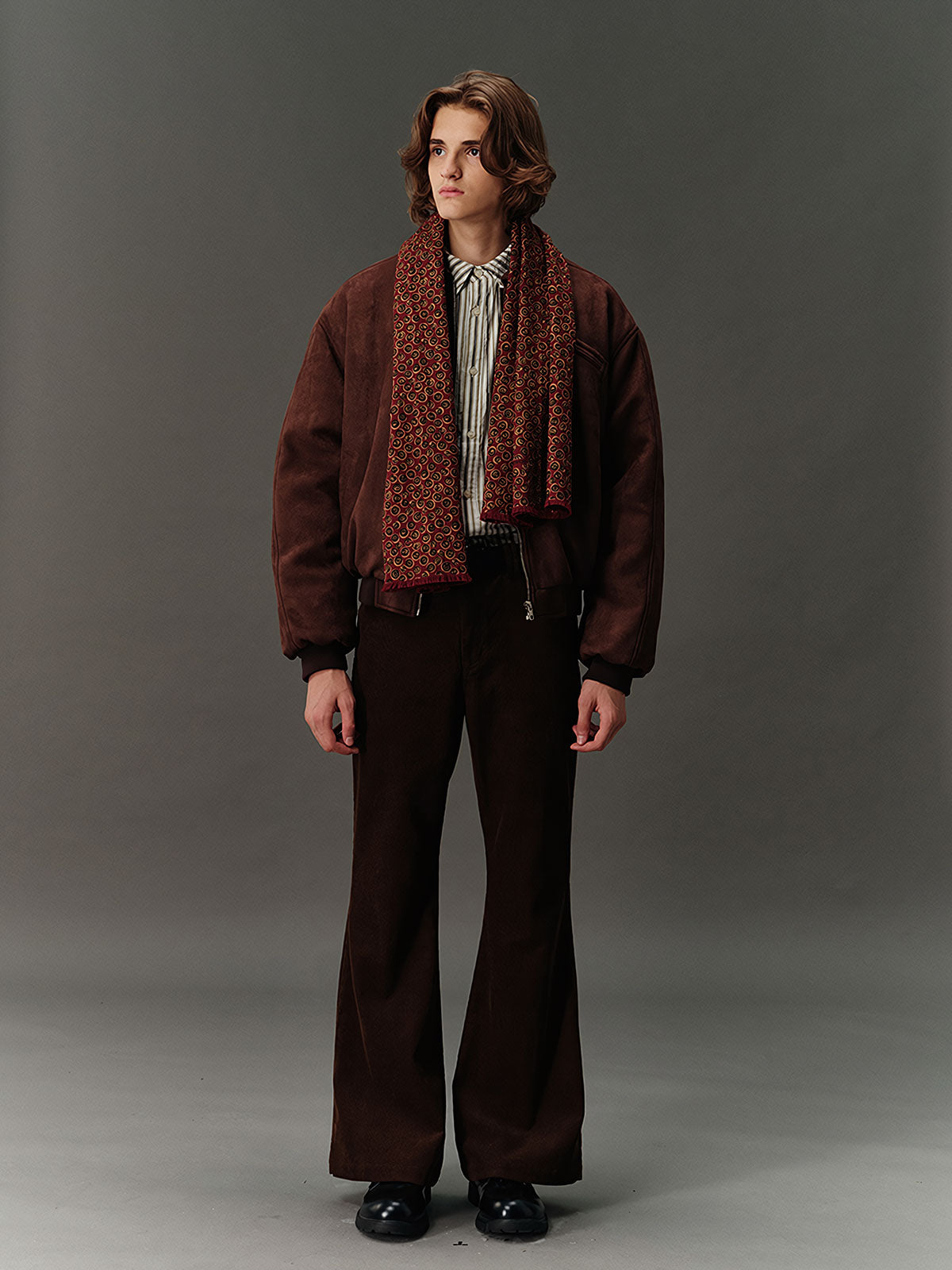 詳細画像: スエード調素材の滑らかな表面とキルティング加工による保温性を示すディテールクローズアップ画像。フラップカラーや多機能ポケットのデザインが際立つ。

モデル画像: スエード調ショート丈ダウンジャケットを着用したモデルのコーディネート例。レトロなブラウンカラーがヴィンテージ感を演出し、カジュアルパンツやワークパンツと相性抜群な秋冬スタイル。