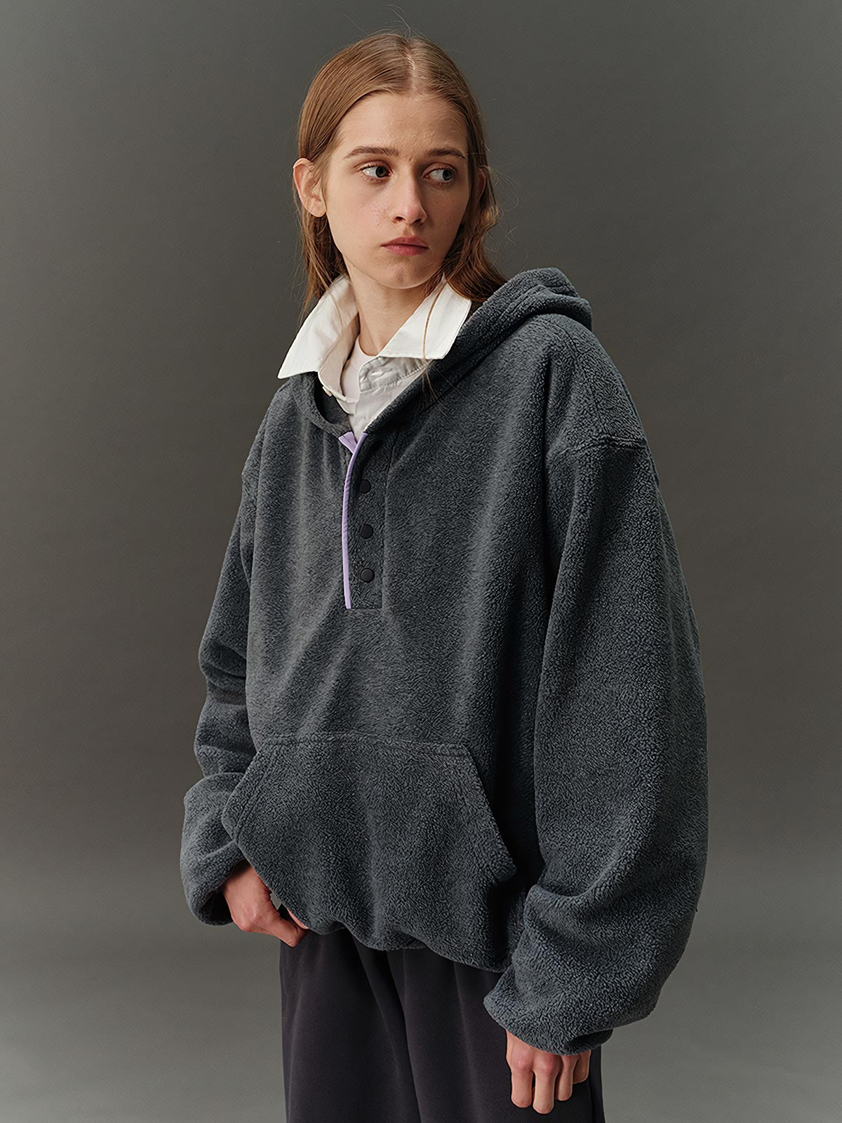 詳細画像: ハーフジップデザインと、シルエット調節可能な裾ドローコードのディテールクローズアップ画像。柔らかなフリース素材の質感が際立つ。

モデル画像: ハーフジップフリースフード付きスウェットを着用したモデルのコーディネート例。デニムやスウェットパンツと合わせたカジュアルでトレンド感あふれるスタイリングを表現。