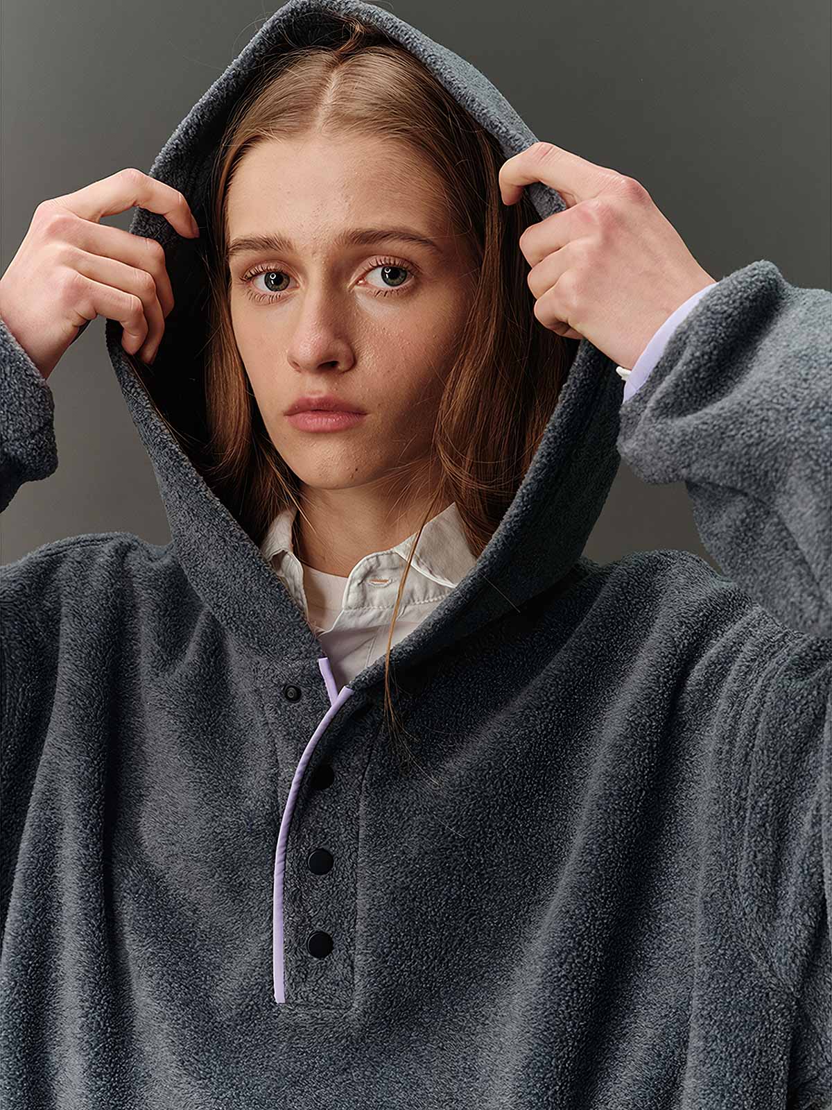 詳細画像: ハーフジップデザインと、シルエット調節可能な裾ドローコードのディテールクローズアップ画像。柔らかなフリース素材の質感が際立つ。

モデル画像: ハーフジップフリースフード付きスウェットを着用したモデルのコーディネート例。デニムやスウェットパンツと合わせたカジュアルでトレンド感あふれるスタイリングを表現。