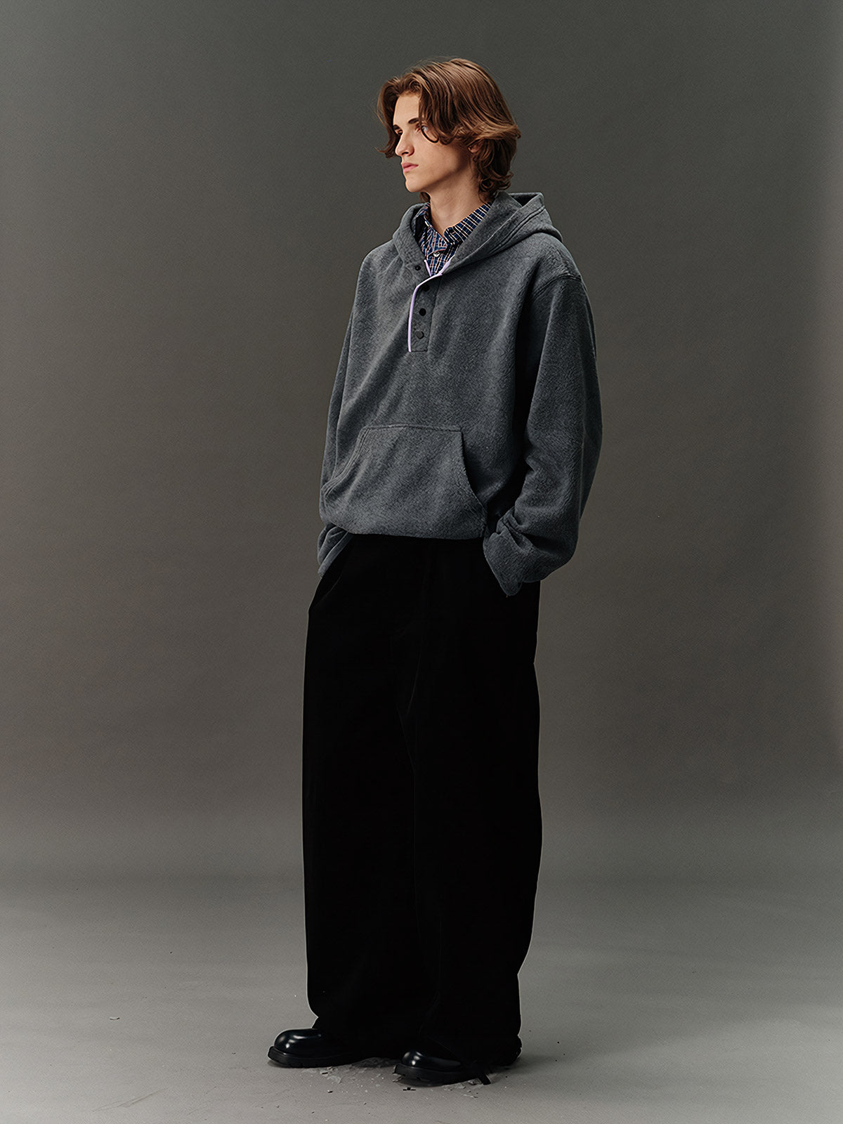 詳細画像: ハーフジップデザインと、シルエット調節可能な裾ドローコードのディテールクローズアップ画像。柔らかなフリース素材の質感が際立つ。

モデル画像: ハーフジップフリースフード付きスウェットを着用したモデルのコーディネート例。デニムやスウェットパンツと合わせたカジュアルでトレンド感あふれるスタイリングを表現。