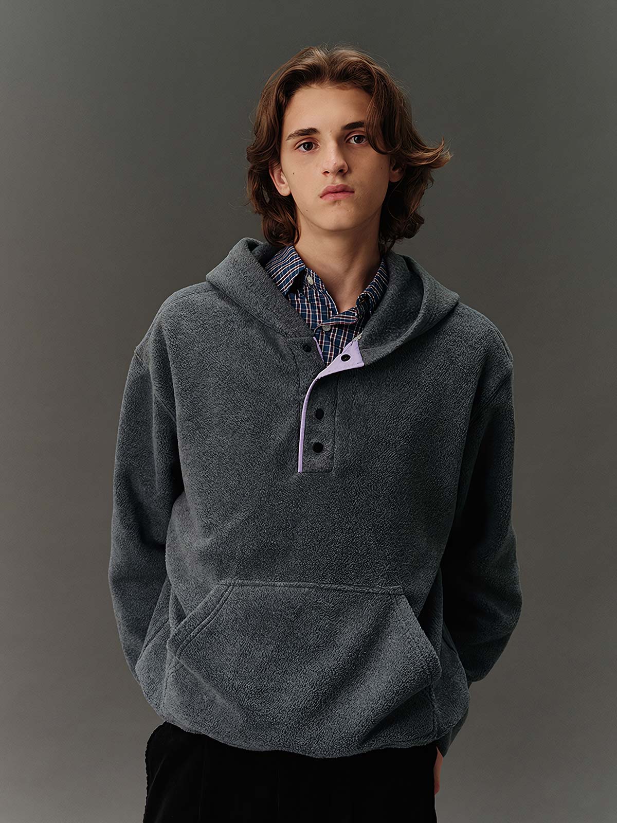 詳細画像: ハーフジップデザインと、シルエット調節可能な裾ドローコードのディテールクローズアップ画像。柔らかなフリース素材の質感が際立つ。

モデル画像: ハーフジップフリースフード付きスウェットを着用したモデルのコーディネート例。デニムやスウェットパンツと合わせたカジュアルでトレンド感あふれるスタイリングを表現。