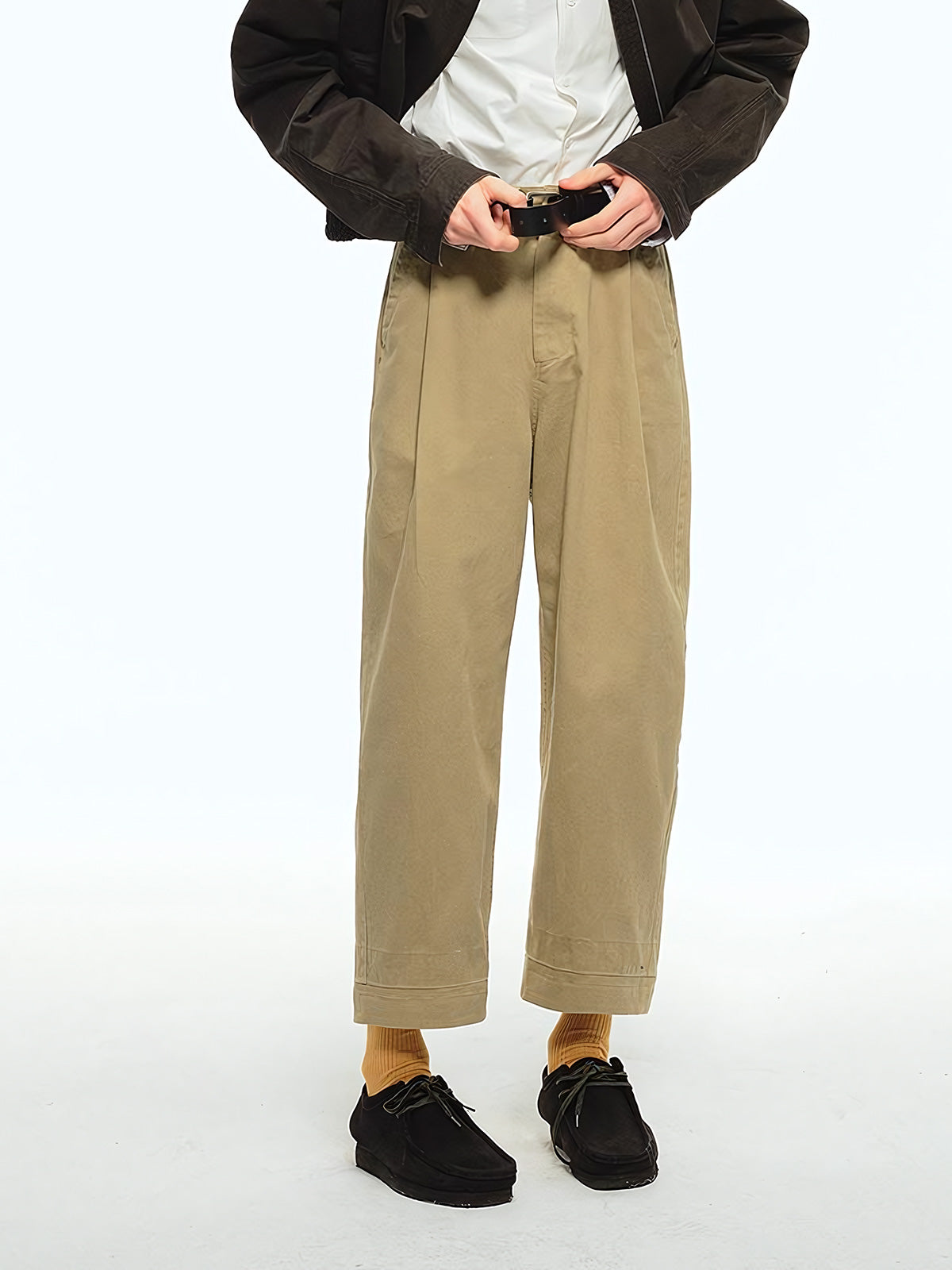 詳細画像: ウエストのプリーツディテールとサンドウォッシュ加工のクローズアップ、自然な色褪せ感と立体感を強調
モデル画像: モデルが九分テーパードカジュアルパンツを着用し、ヴィンテージファッションスタイルを演出、シンプルで洗練されたコーディネート