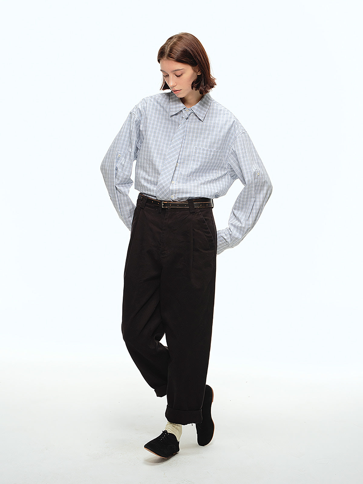 詳細画像: ウエストのプリーツディテールとサンドウォッシュ加工のクローズアップ、自然な色褪せ感と立体感を強調
モデル画像: モデルが九分テーパードカジュアルパンツを着用し、ヴィンテージファッションスタイルを演出、シンプルで洗練されたコーディネート