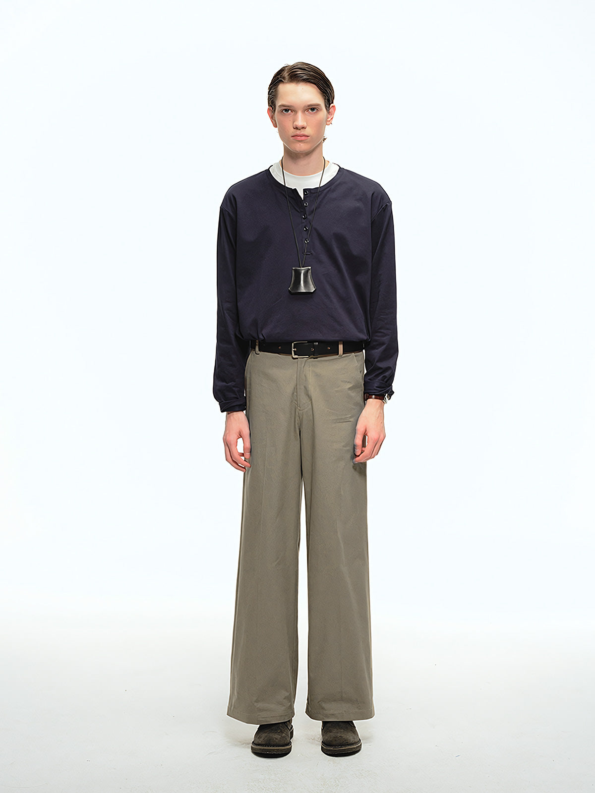 詳細画像: 前中プリーツデザインとハイウエストディテールのクローズアップ、優雅なドレープ感と流れるようなラインを強調
モデル画像: ワイドレッグスラックスをシンプルなシャツと合わせた通勤スタイル、ヴィンテージ感あふれるミニマルなコーディネート