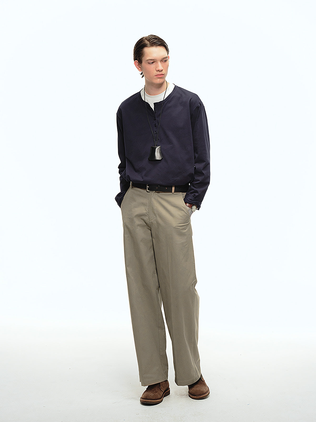 詳細画像: 前中プリーツデザインとハイウエストディテールのクローズアップ、優雅なドレープ感と流れるようなラインを強調
モデル画像: ワイドレッグスラックスをシンプルなシャツと合わせた通勤スタイル、ヴィンテージ感あふれるミニマルなコーディネート