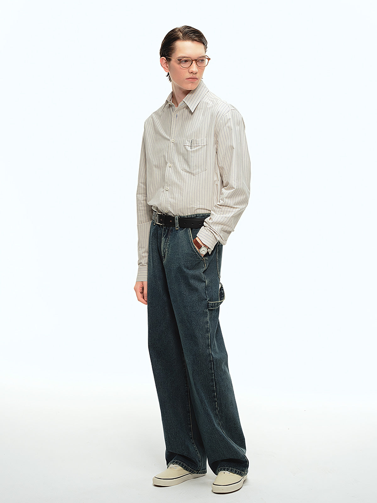 詳細画像: ブルーの細ストライプと胸元のポケットディテール特写、ヴィンテージカットが強調された部分
モデル画像: モデルが100%コットンストライプシャツを着用し、シンプルでヴィンテージ感のあるカジュアルスタイルを披露