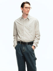 詳細画像: ブルーの細ストライプと胸元のポケットディテール特写、ヴィンテージカットが強調された部分
モデル画像: モデルが100%コットンストライプシャツを着用し、シンプルでヴィンテージ感のあるカジュアルスタイルを披露