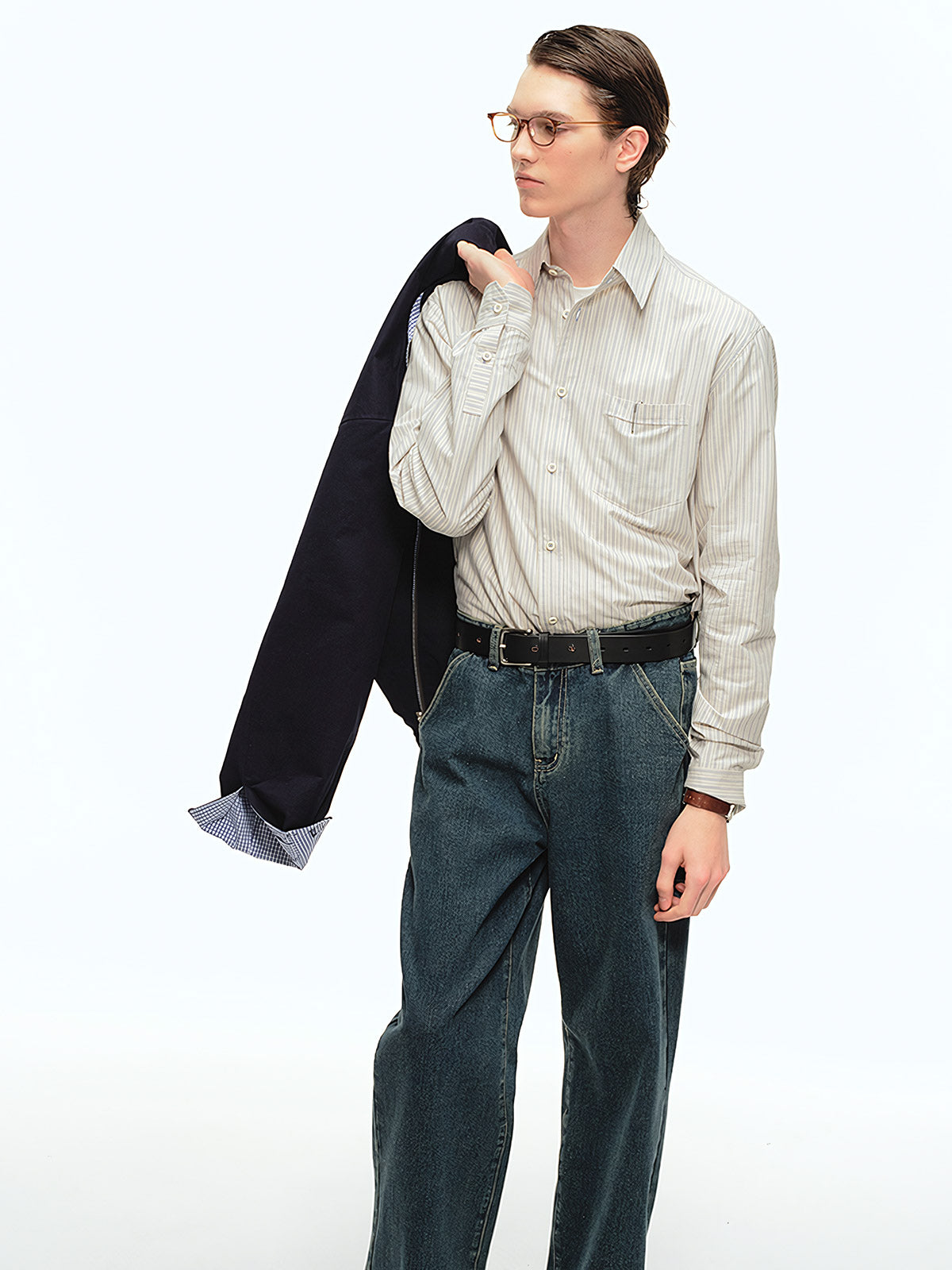 詳細画像: ブルーの細ストライプと胸元のポケットディテール特写、ヴィンテージカットが強調された部分
モデル画像: モデルが100%コットンストライプシャツを着用し、シンプルでヴィンテージ感のあるカジュアルスタイルを披露
