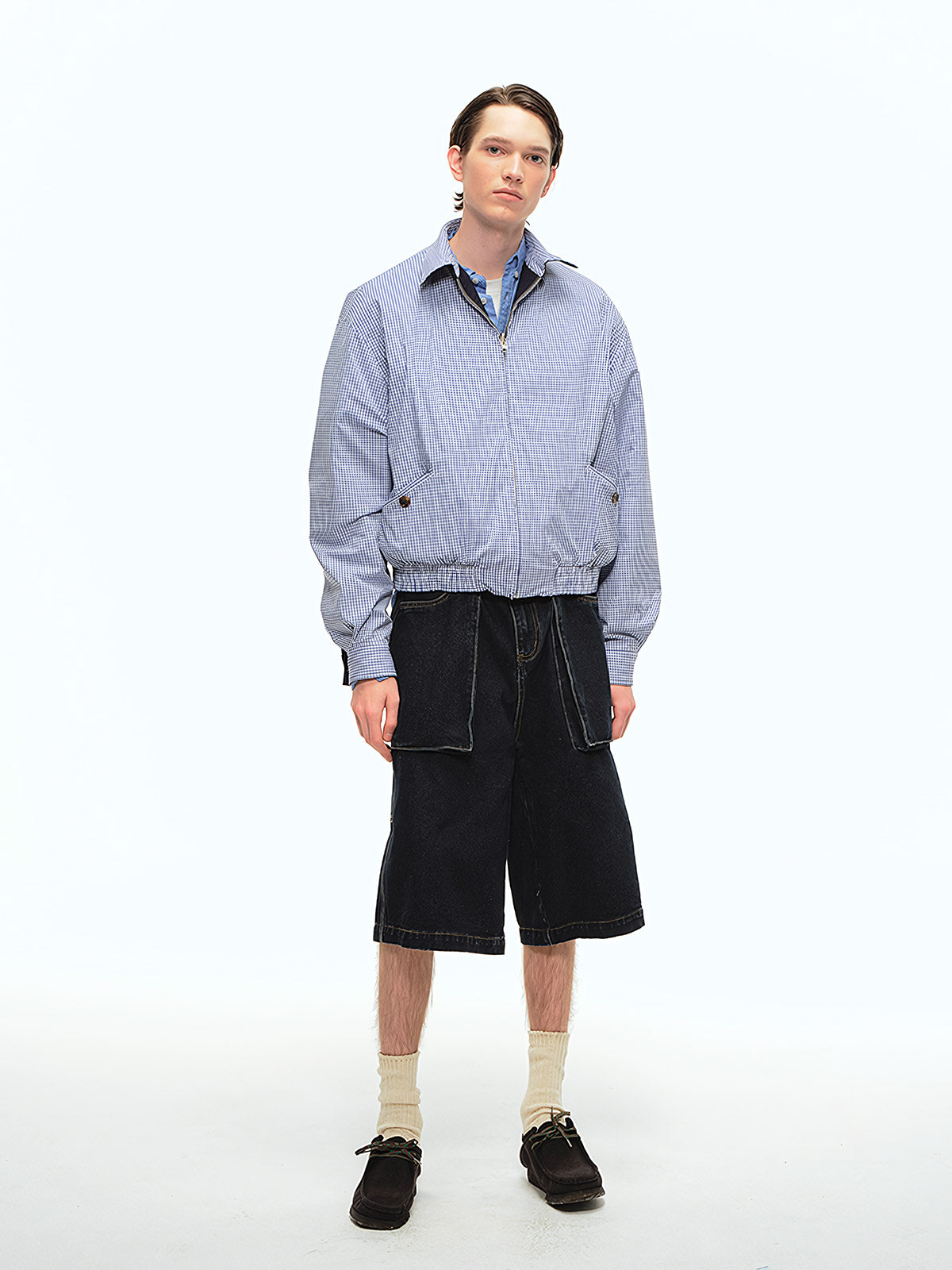 詳細画像: 袖口のバイカラー折り返しデザインとリバーシブルデザインのディテール、ヴィンテージチェック柄と単色面が交互に見える部分のクローズアップ
モデル画像: モデルがリバーシブルハリントンジャケットを使ったヴィンテージ感とモダンなコーディネート、カジュアルなスタイルを披露