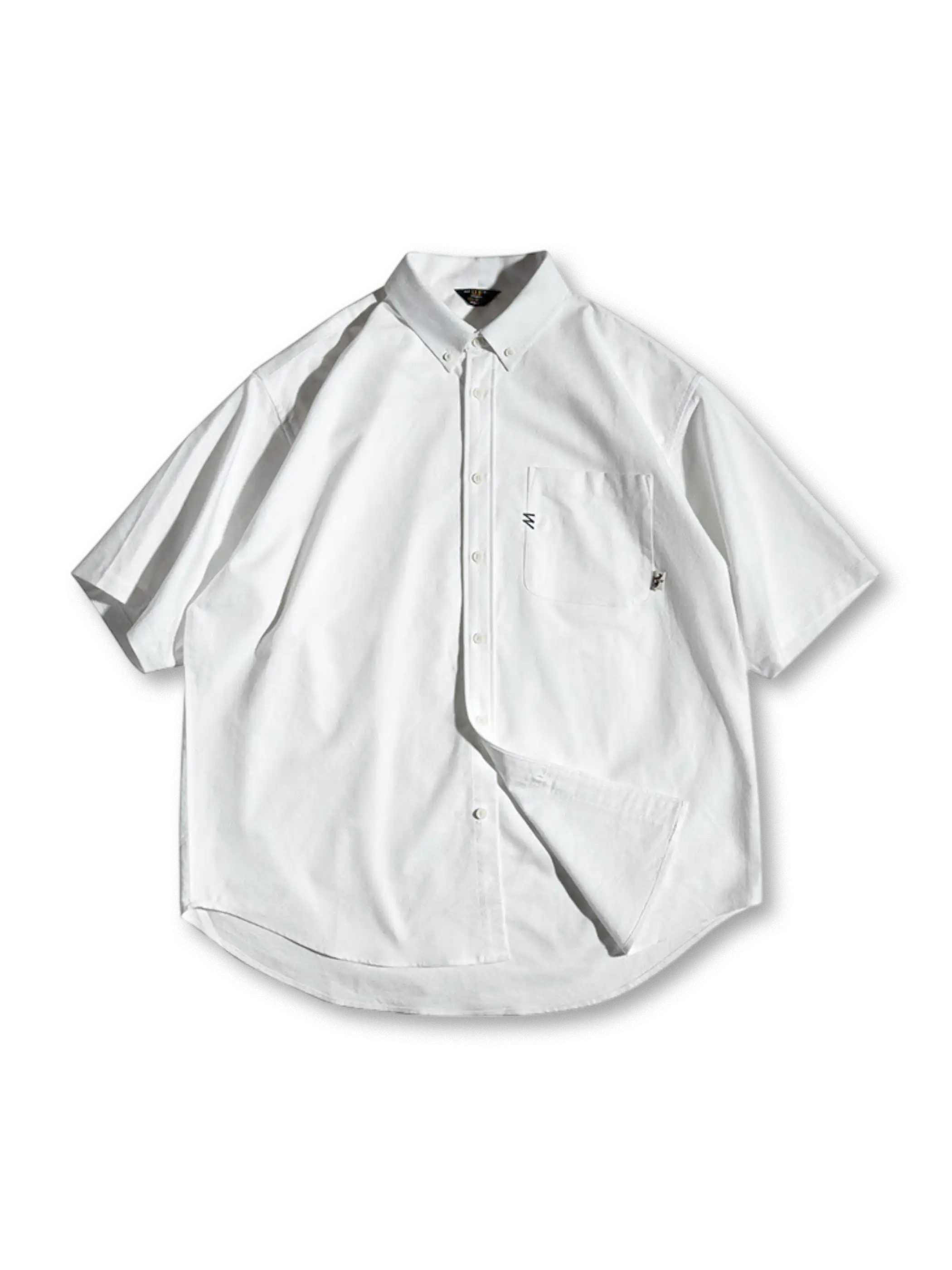 ゆったりとした半袖のボタンダウンシャツ全体像。胸の小さな刺繍とラウンドカットの裾が特徴的