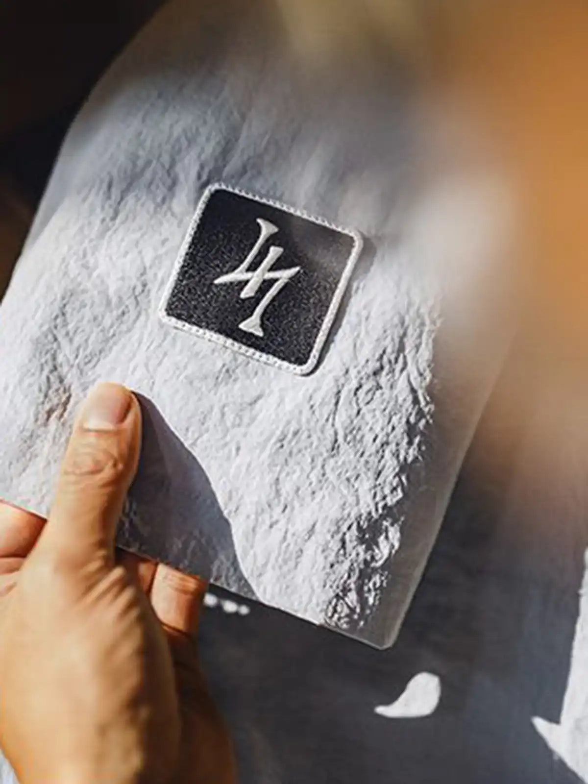 薄手のナイロン生地と2つの胸ポケットが特徴の半袖シャツ正面全体。肩のロゴ刺繍や控えめなスタイリングがわかる