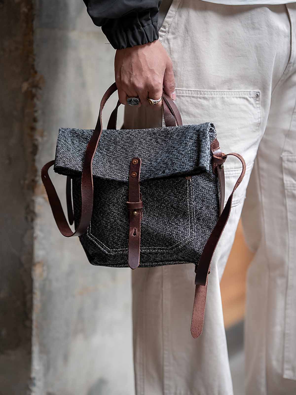 モデル画像: モデルがヴィンテージスタイルのメッセンジャーバッグを持っている様子