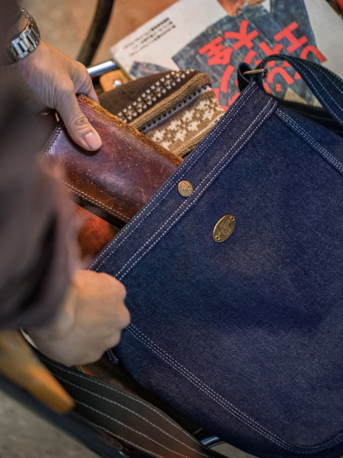 モデルがデニムメッセンジャーバッグを使用し、ヴィンテージ感あふれるカジュアルコーデを披露