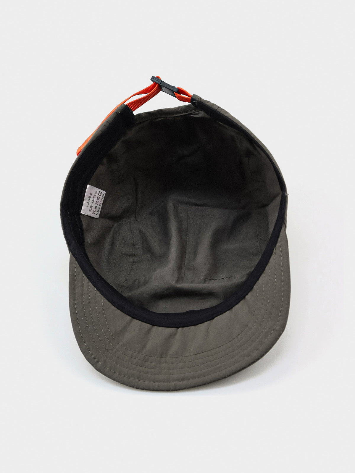 エクスプローラーハットの通気孔とオレンジ色のプルタブのクローズアップ、耐摩耗性に優れたナイロン素材。