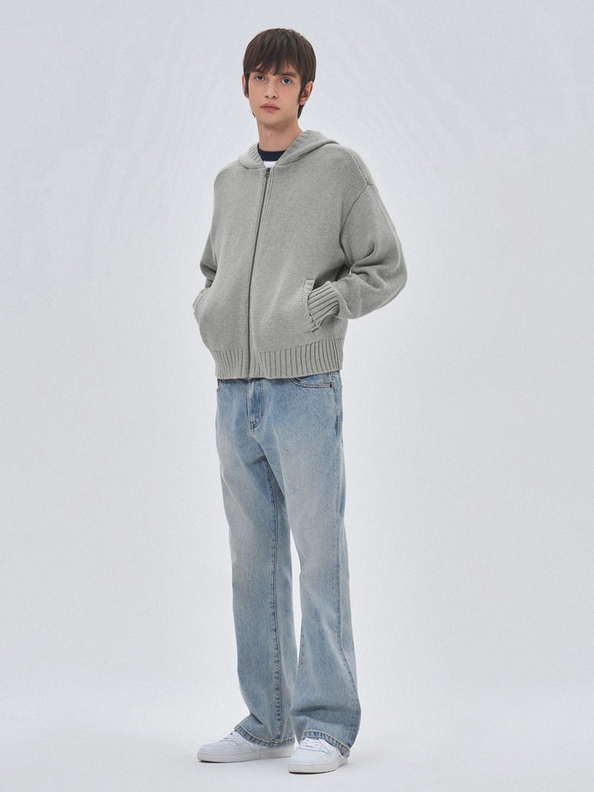 詳細画像: ケーブル編みディテールとマットシルバージッパーの特写。細部の編み模様とジッパーが際立つ画像。

モデル画像: ケーブル編みカーディガンとデニムを組み合わせた秋冬カジュアルスタイル。モデルがリラックスした日常スタイルを披露。