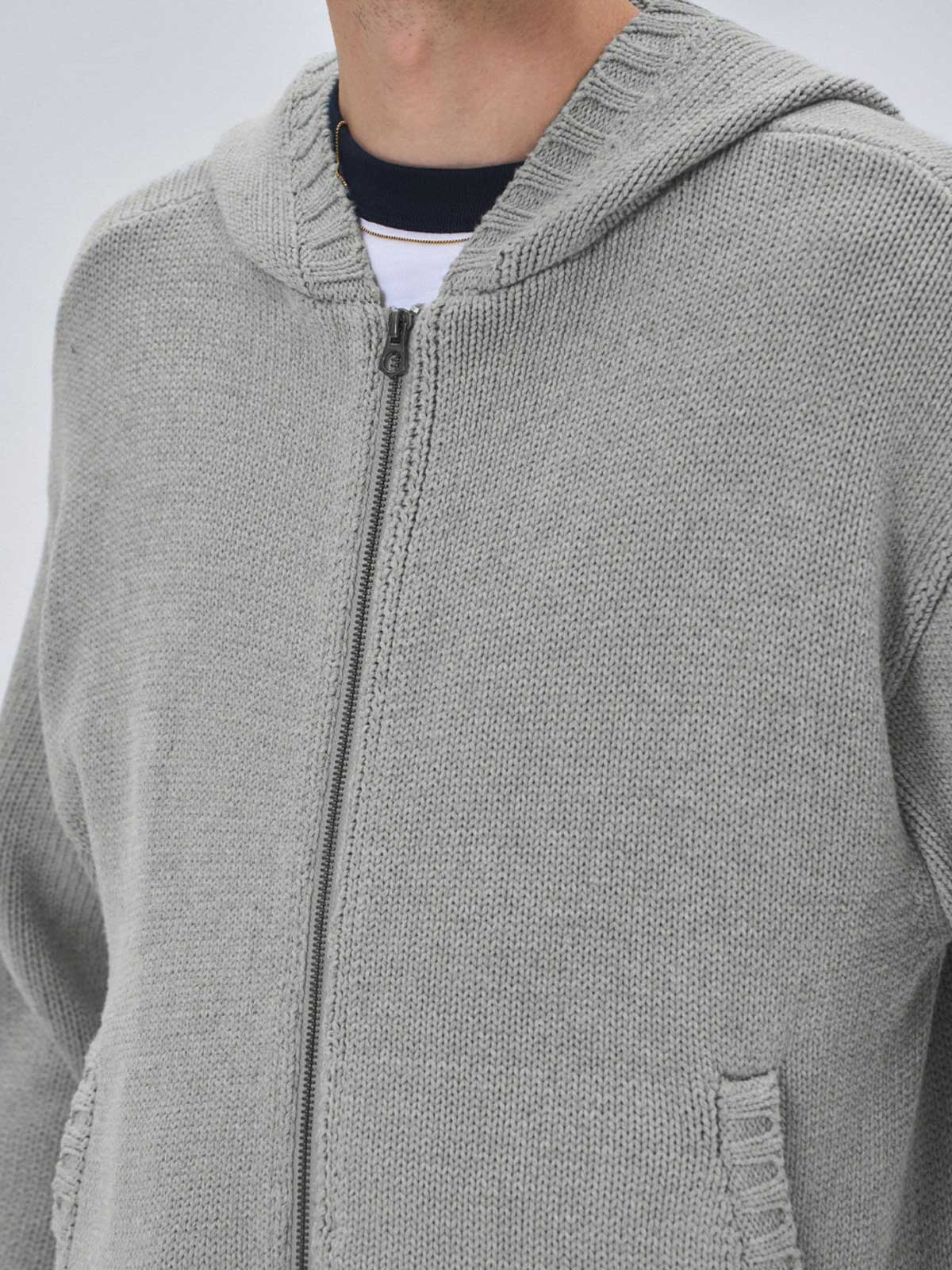 詳細画像: ケーブル編みディテールとマットシルバージッパーの特写。細部の編み模様とジッパーが際立つ画像。

モデル画像: ケーブル編みカーディガンとデニムを組み合わせた秋冬カジュアルスタイル。モデルがリラックスした日常スタイルを披露。