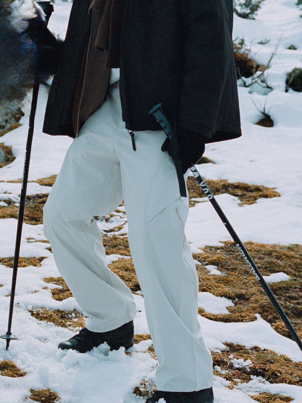 詳細画像: 異形カッティングとジップポケットのディテール展示 - 立体感のあるビジュアルと収納力。
モデル画像: モデル着用のアウトドアスタイルシェルパンツのスタイリング - 日常のカジュアルシーンにも対応。