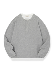 製品画像: ヘンリーネック レイヤード風 ワッフル 長袖Tシャツ全体展示。ヘンリーネックとレイヤード風デザインが融合したスタイル、ワッフル生地が独特の質感を引き立て、洗練されたカジュアル感を演出。

詳細画像: ワッフル生地のテクスチャーとレイヤードデザインの特写。独自の質感とディテールが着こなしに深みを加え、シンプルでありながらもデザイン性が光る。