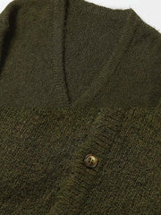 製品画像: アルパカロングヘア混紡ニットセーターの全体展示。クラシックなオープンカラーデザインとケーブル編み模様が特徴で、レトロ感と暖かさを演出するエレガントな一着。

詳細画像: ニットのケーブル編み模様と木製ボタンのディテール特写。温かみのある素材とクラシックなデザインが、日常的に使える上品さを引き立てます。