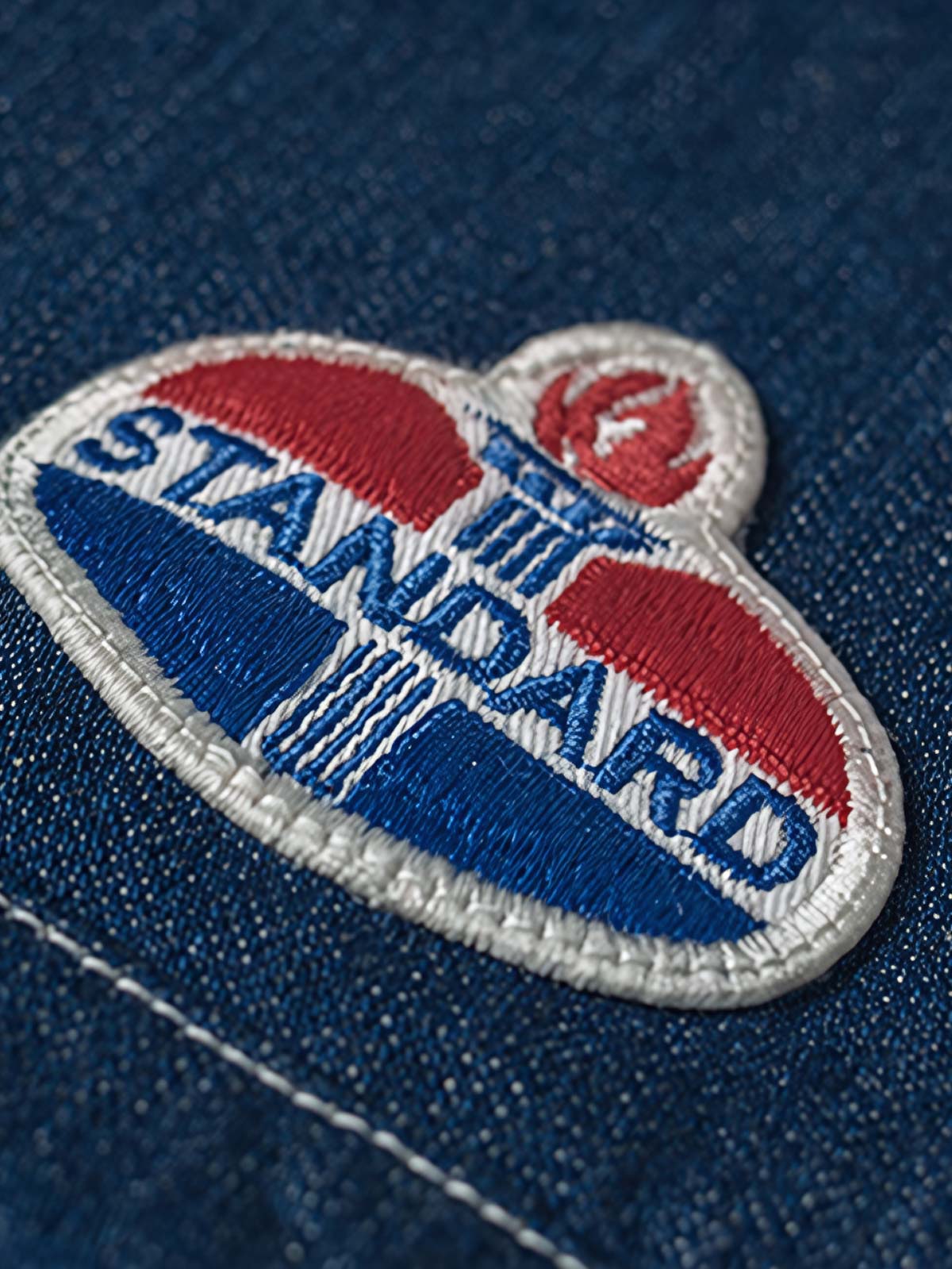 シャツの刺繍パッチとデニム素材の詳細をクローズアップで表示し、精巧な仕上がりを確認できます。