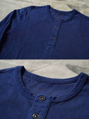 製品画像
伝統的な藍染め技法を施したヘンリーネック長袖Tシャツの全体画像。260gの厚手コットン素材とクラシックなデザインが際立つ一枚。

詳細画像
藍染めによる独特なグラデーションと、染色されたコットン縫い目の細部を強調したクローズアップ画像。1点ごとに異なる色合いや職人の手作り感が魅力。