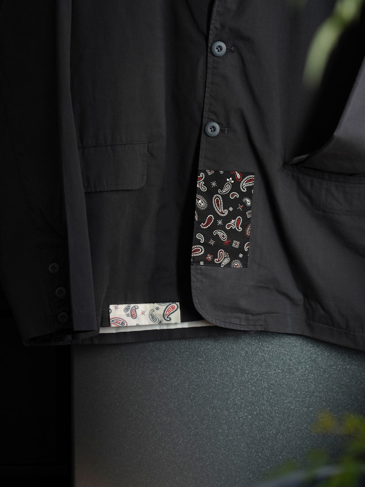 製品画像
「ヴィンテージ ペイズリー柄パッチルーズフィット テーラードジャケット全体イメージ。撥水素材と不規則なペイズリー柄パッチデザインが特徴のカジュアルな一着。」

詳細画像
「不規則に配置されたペイズリー柄パッチと高密度ヘリンボーン裏地のディテールクローズアップ。機能性とファッション性を融合したデザイン。」