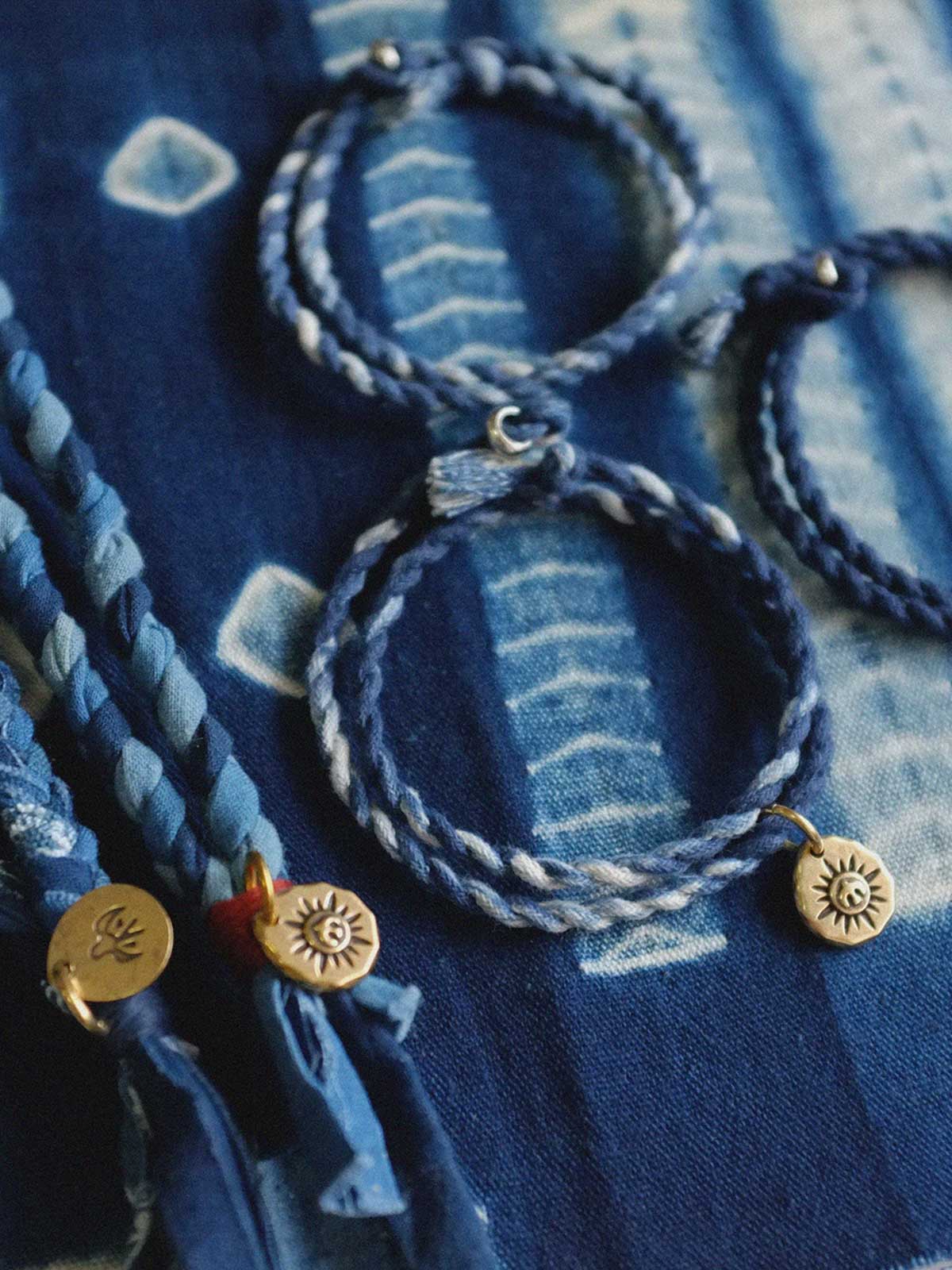 繊細な手作り編み込みと藍染めの詳細が際立つ飛鳥コインネックレスのクローズアップ。