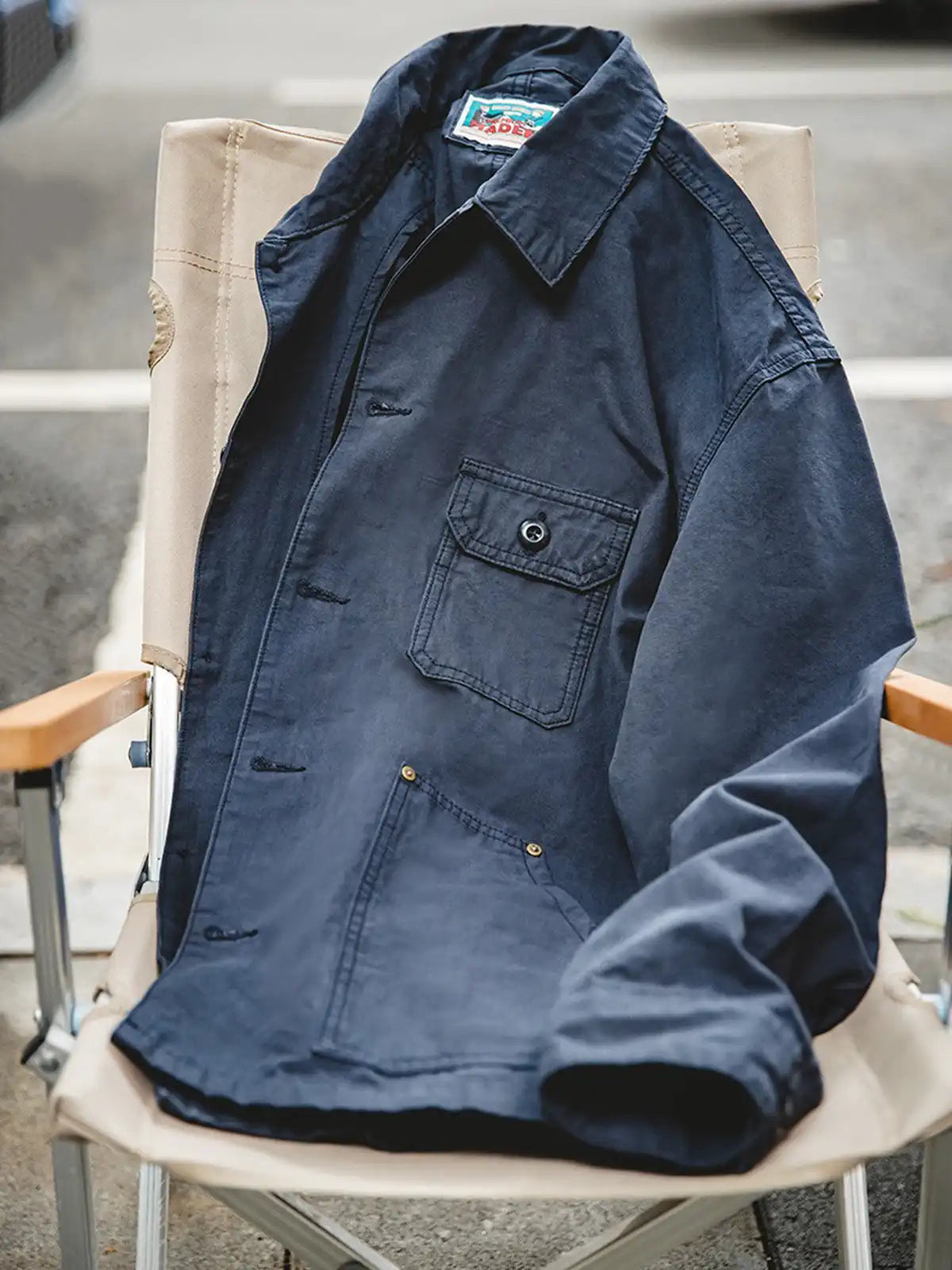 ネイビーのフレンチワークスタイル・コーチジャケット全体像。左右非対称に施された4つのポケットがポイント