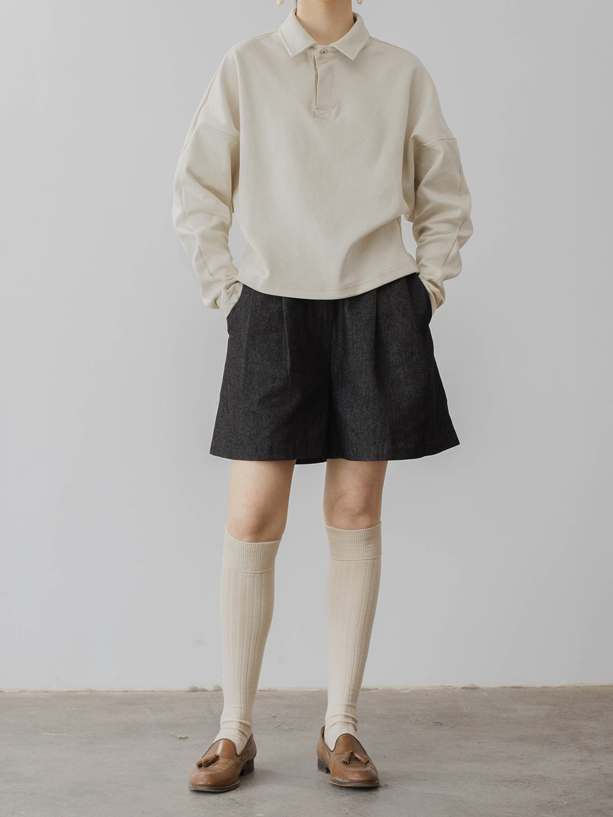 モデルがハイウエストデニムショートパンツを着用し、スタイリッシュなシルエットを披露