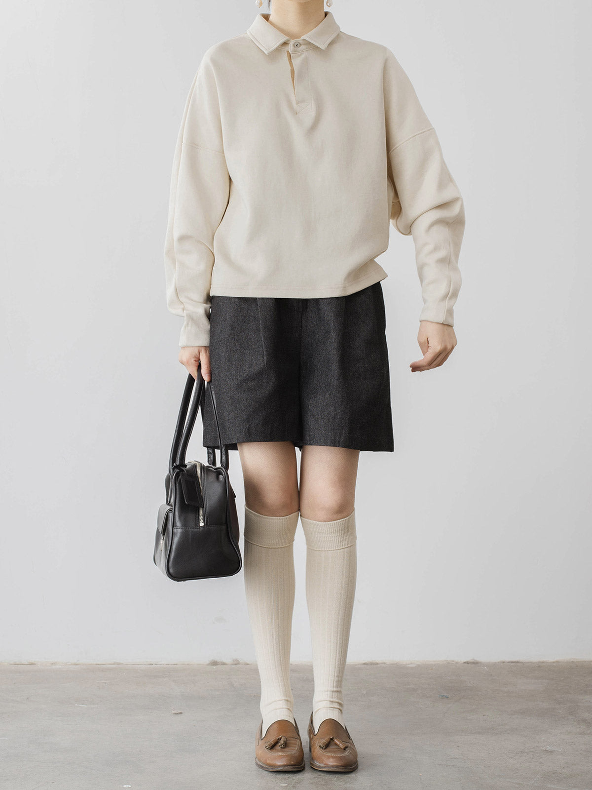 モデルがハイウエストデニムショートパンツを着用し、スタイリッシュなシルエットを披露