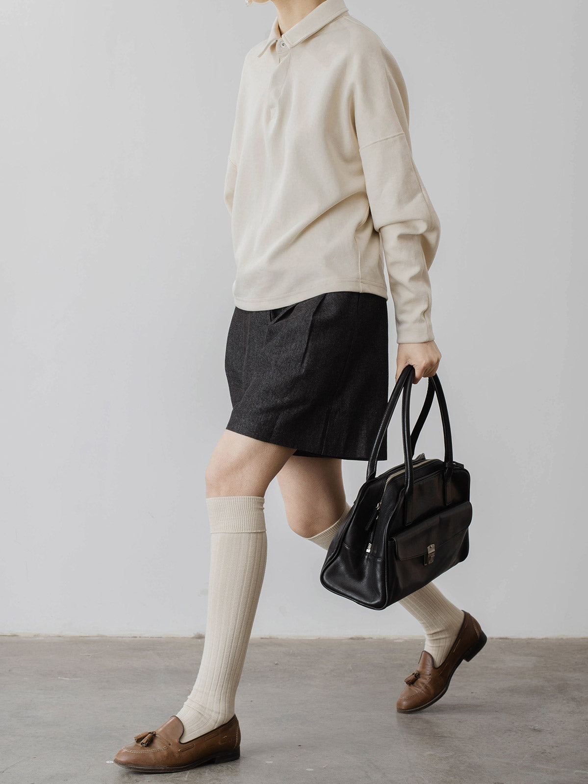 モデルがハイウエストデニムショートパンツを着用し、スタイリッシュなシルエットを披露