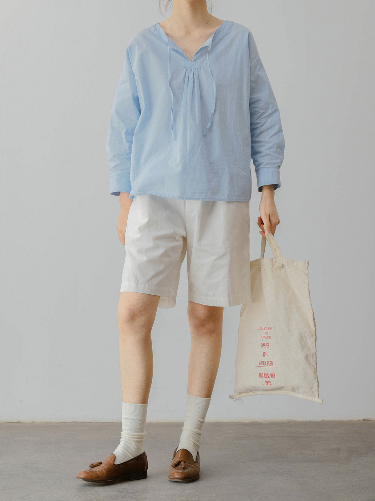 モデルがフランス風レトロ文芸風のベビーブルー ルーズフィット ラウンドネック ドローコード コットンシャツを着用し、文芸スタイルを披露。