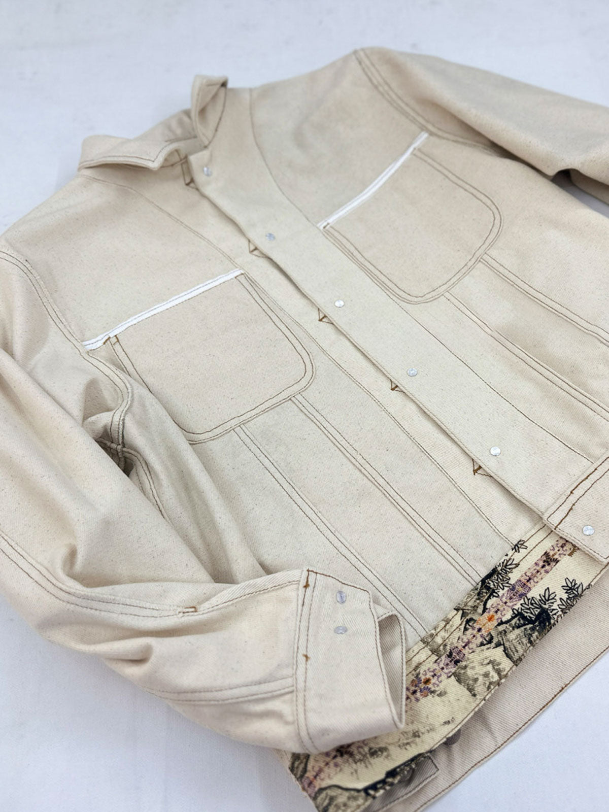 製品画像: 水墨画松柏プリントヴィンテージジャケット全体展示図。東洋美術の水墨画風デザインがジャケット全体に施され、松と柏の自然の美を強調した一着。
詳細画像: ジャケットの金属ボタンと松柏プリントディテールを特写した画像。A+級色堅牢度で、プリントの鮮やかさと耐久性を長期間保つ。