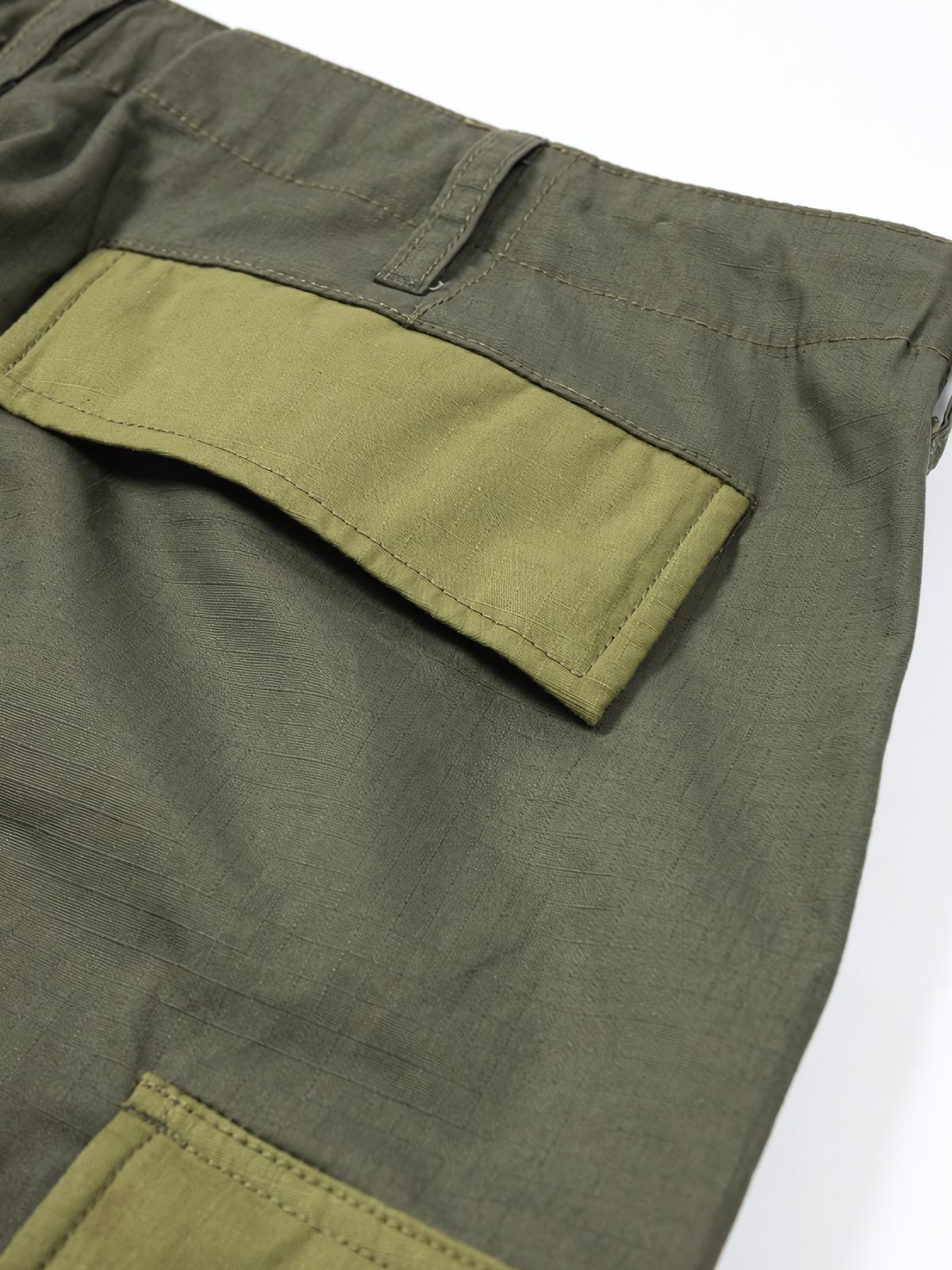 製品画像: パネルポケット付きワークパンツ全体画像、ルーズフィットデザインとドローストリング調節可能
詳細画像: ワークパンツの大きなパネルポケットとドローストリングのディテール