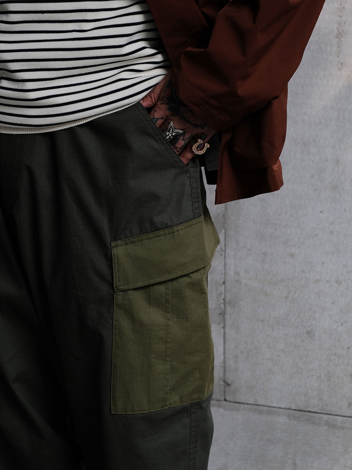 詳細画像: ワークパンツの大きなパネルポケットとドローストリングのディテール
モデル画像: ワークパンツの着用イメージ、日常使いに最適なカジュアルスタイル