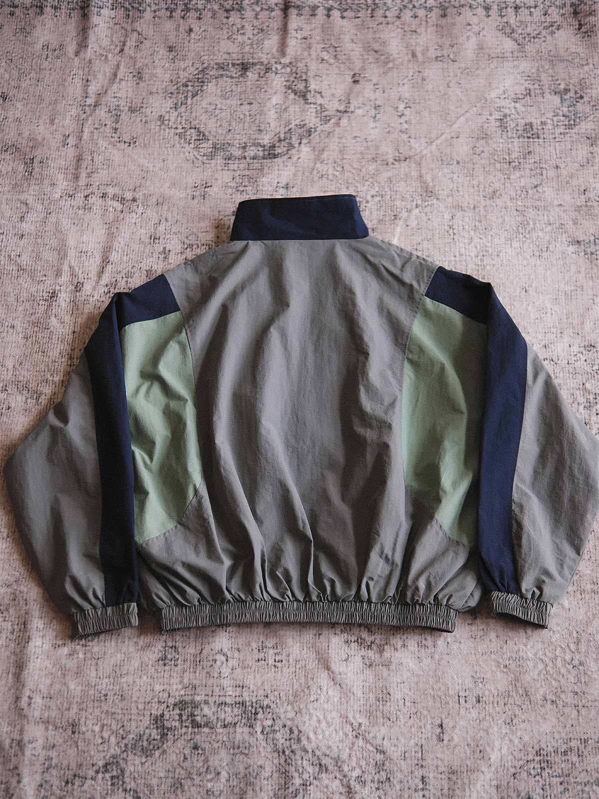 製品画像: ヴィンテージパッチワークコーチジャケットの正面画像、80年代風のカラーブロックデザイン
詳細画像: 防水・防風ナイロン素材とパッチワークディテールが特徴のヴィンテージコーチジャケット