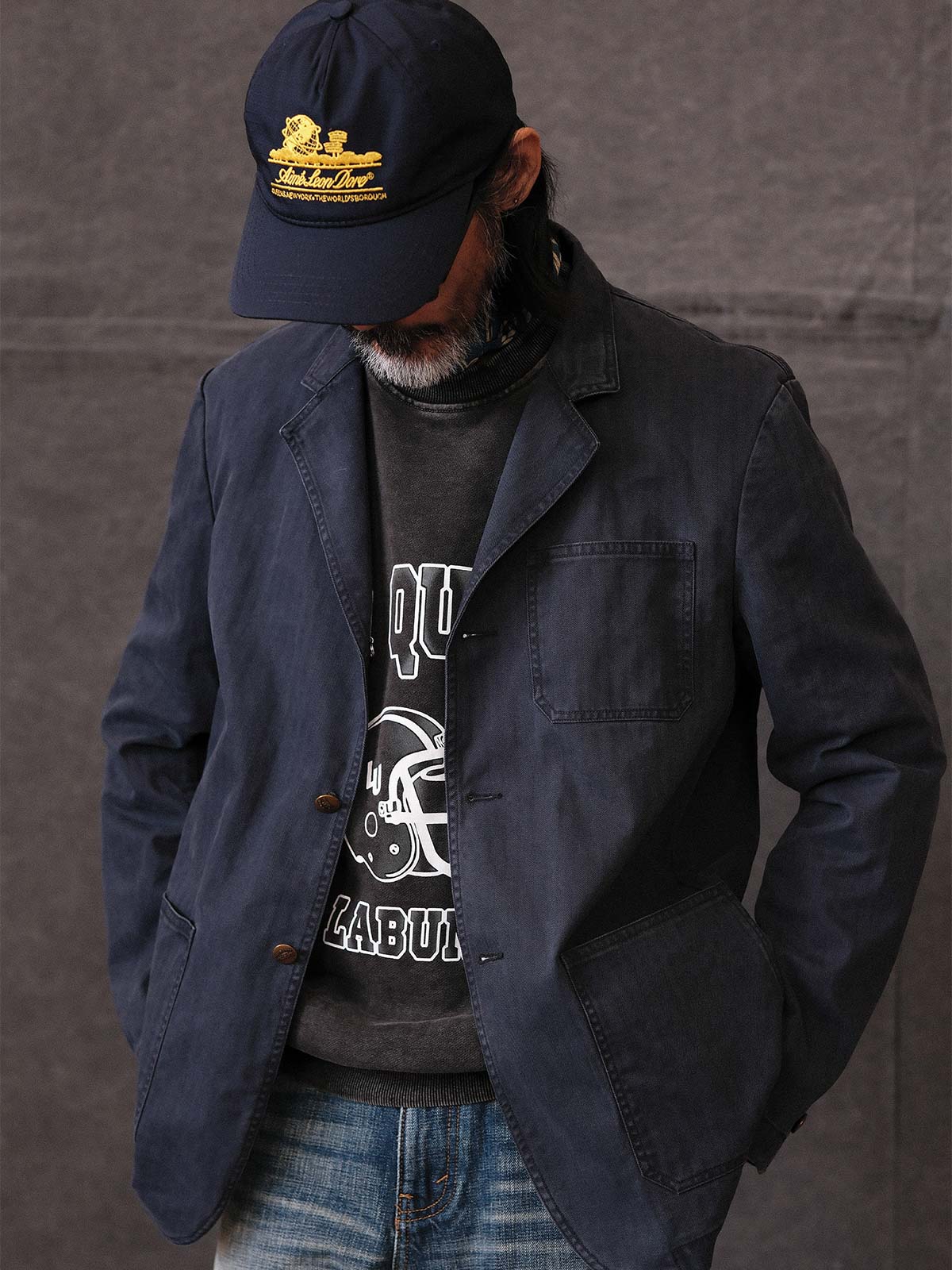 詳細画像: ウォッシュ加工されたヘリンボーン柄の生地とヴィンテージメタルボタンのディテール
モデル画像: ゆるやかなフィットでスタイリッシュなヴィンテージウォッシュジャケットの着用イメージ